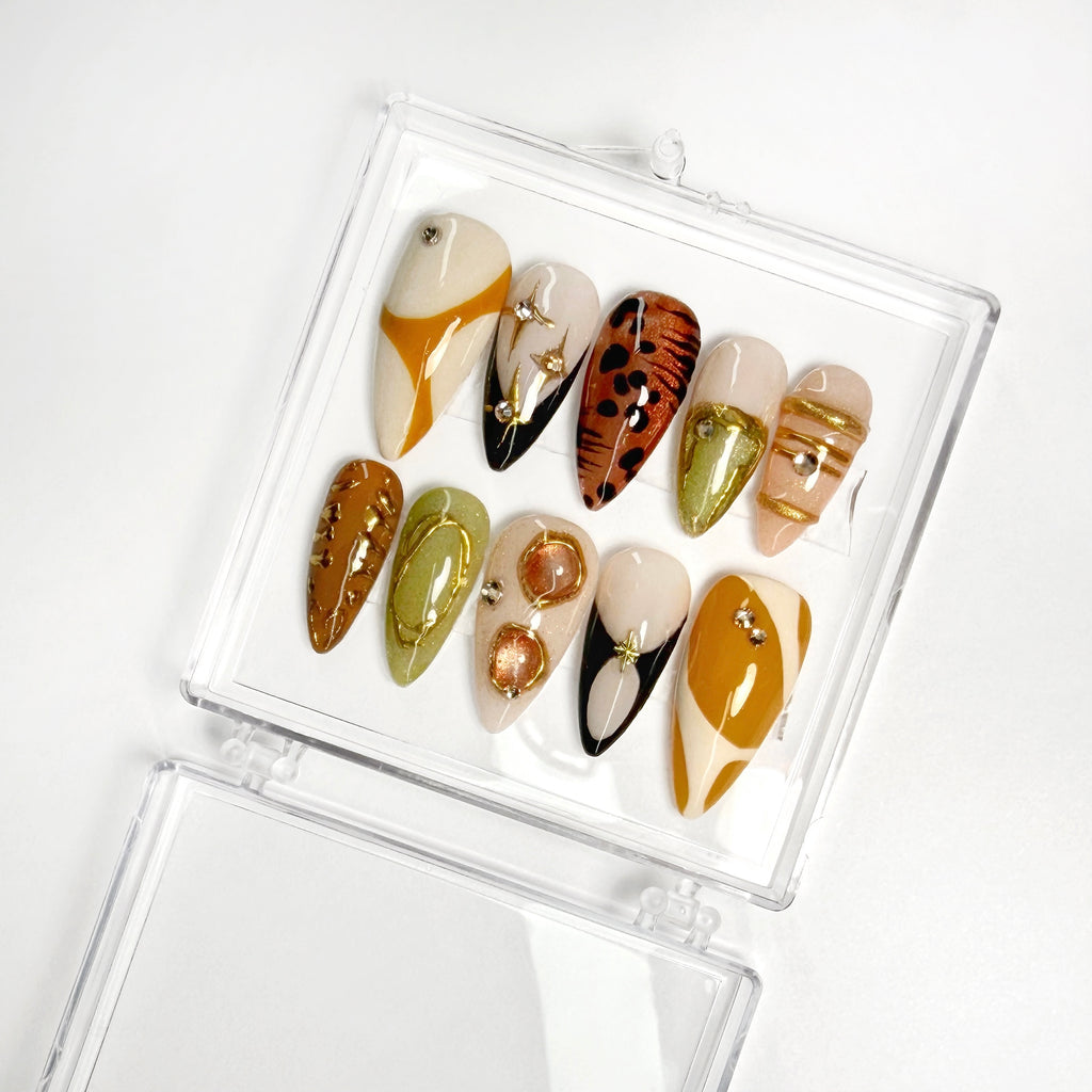 Set of decorative nails in various designs and colors in a clear case on a white background