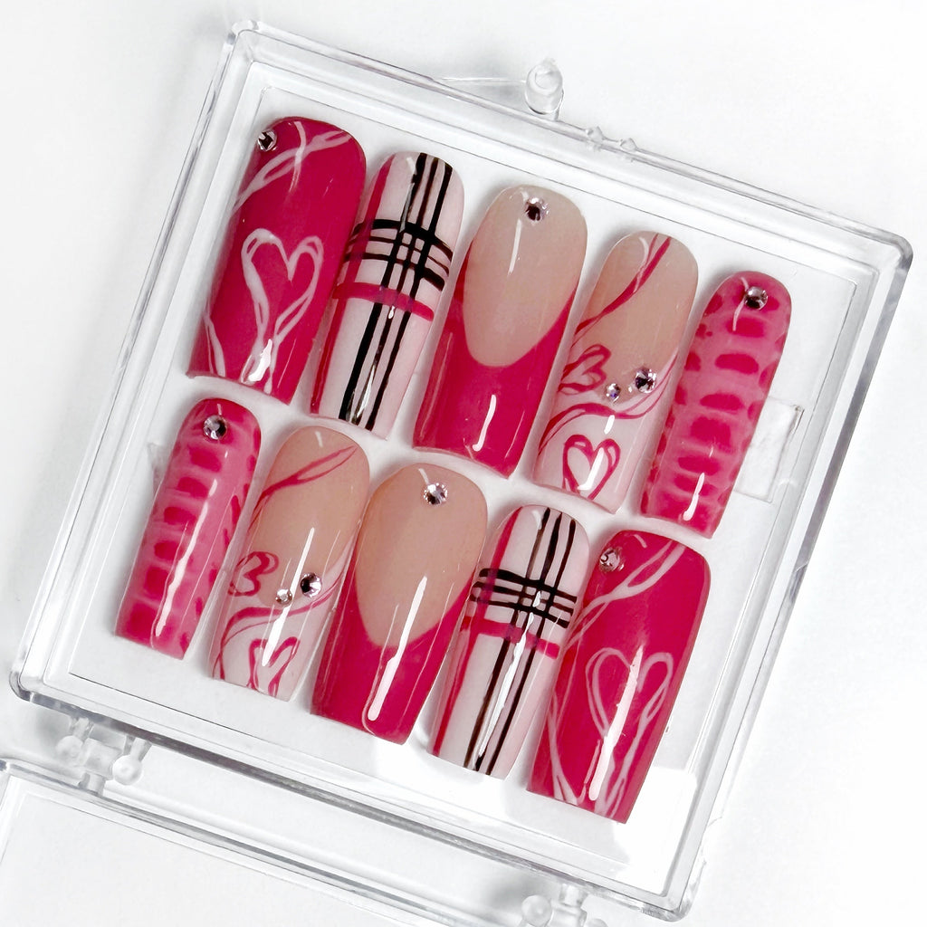 Set of decorative false nails pink with various hearts, French tips, crocodile print, in a clear case on a white background