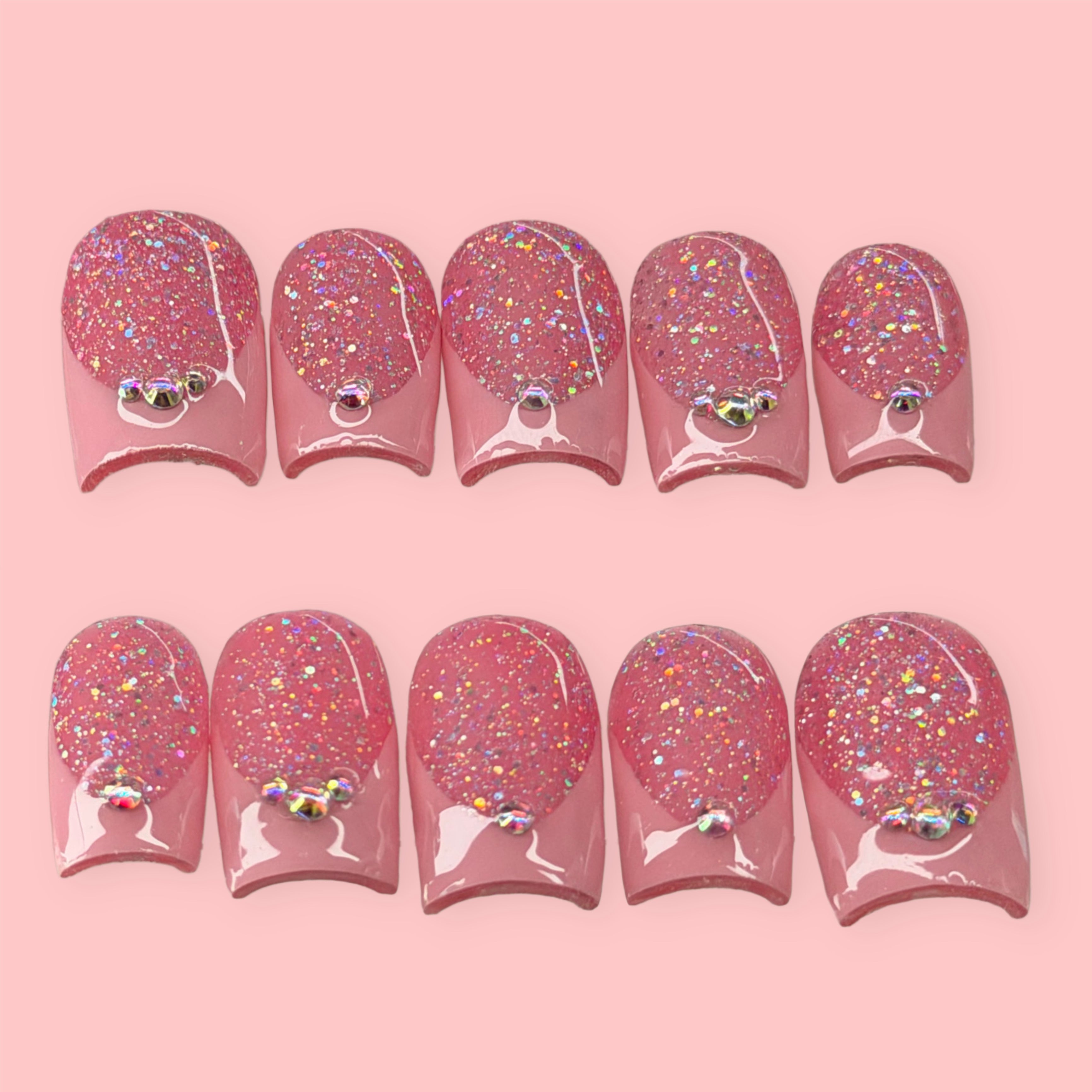 Set of pink glittery nail art designs on a pink background