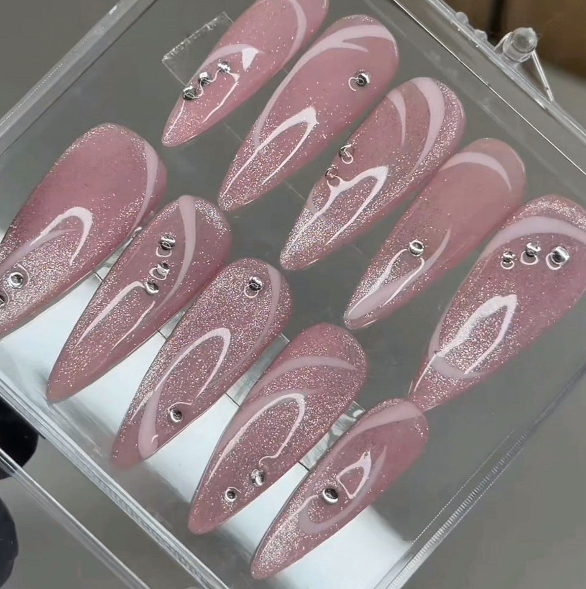 Set of pink glittery false nails in a clear case