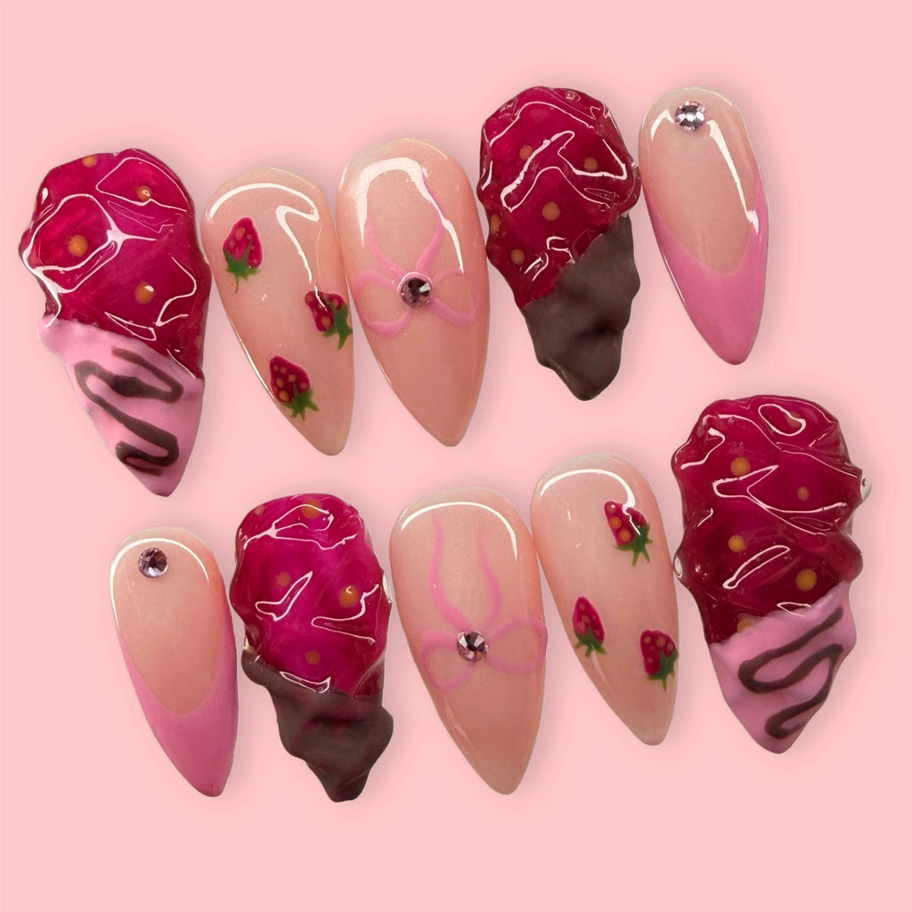 Set of chocolate dipped strawberry nail art designs on a pink background