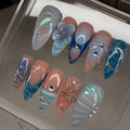 Set of decorative nails with blue floral and shell designs in a plastic clear case.