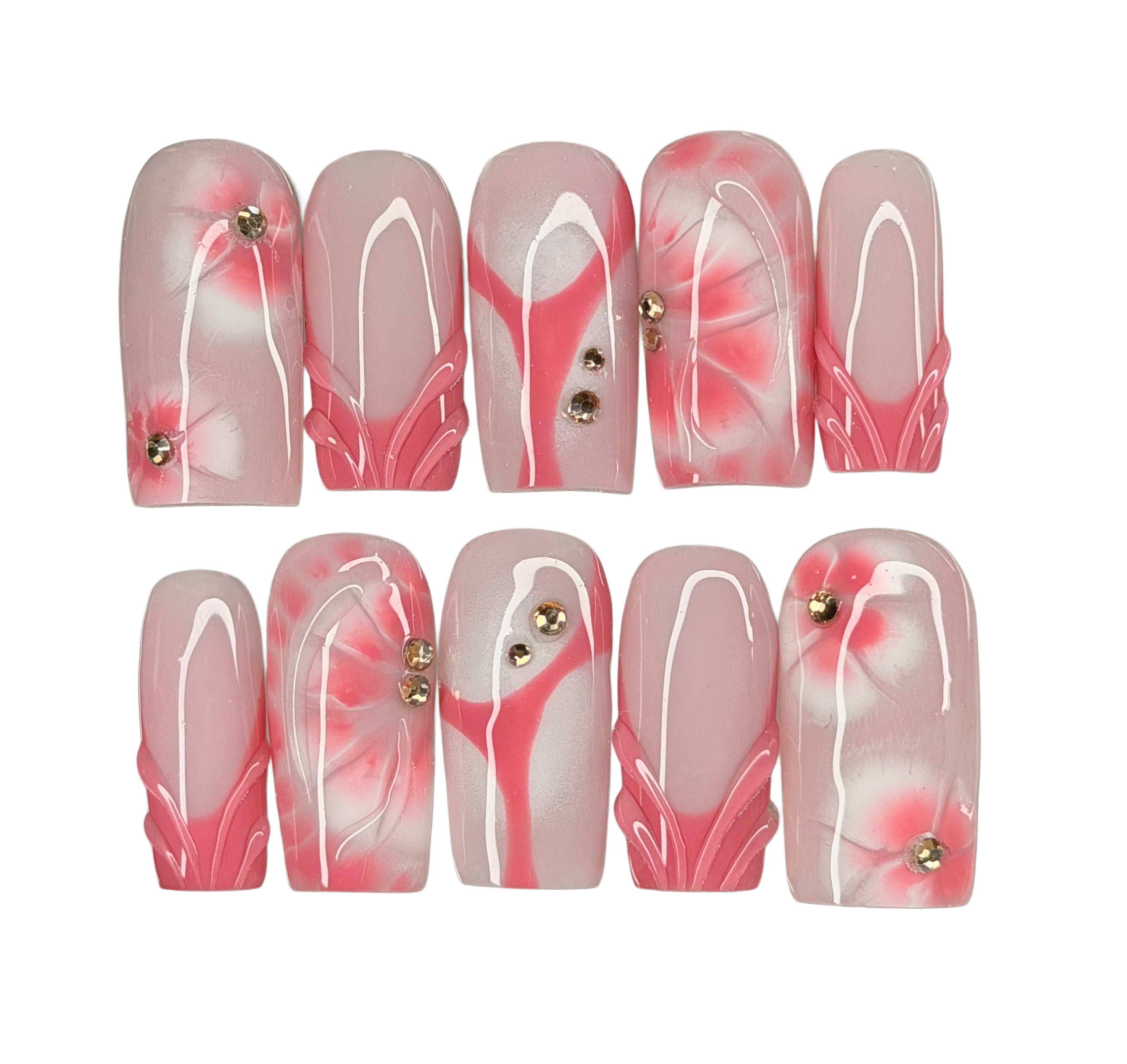 Set of pink and white floral nail art designs on a white background