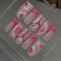 Set of pink and white floral nail art designs in a clear case.