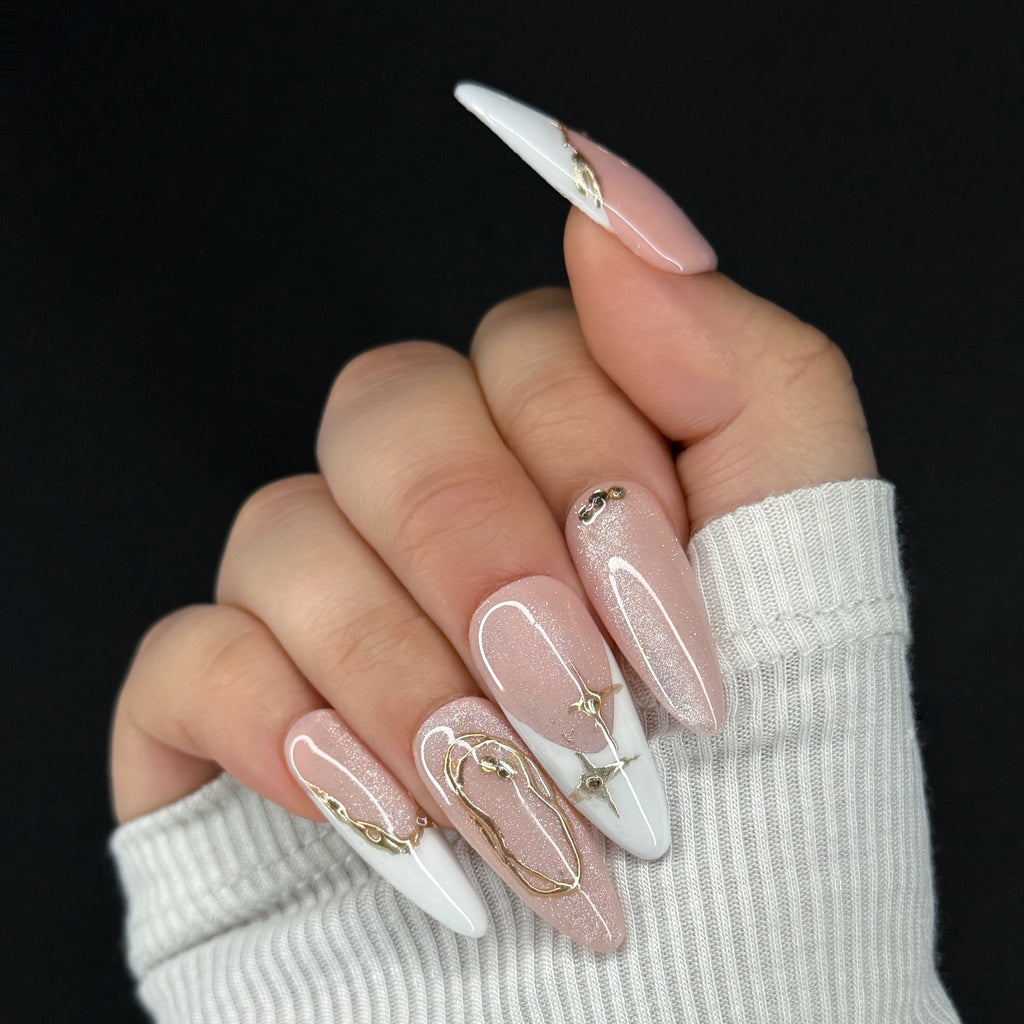 Hand with pink and white nails featuring gold accents against a black background