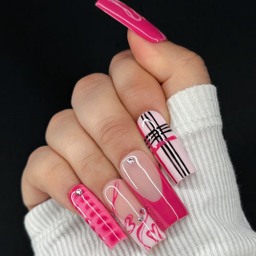 Hand with pink and white checkered nail design on a black background